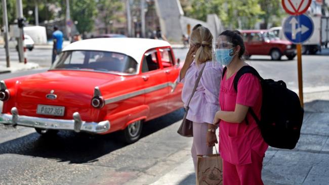Dos personas caminan por La Habana.