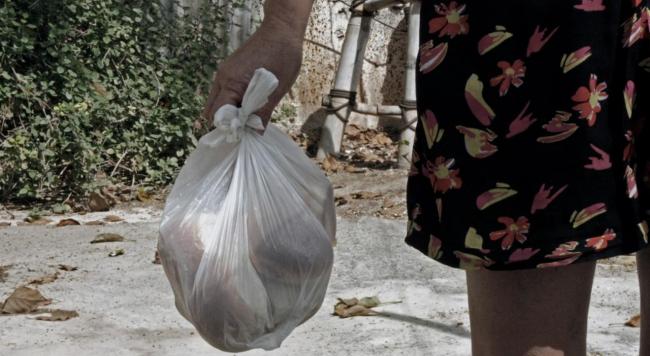 Una mujer cubana lleva el pan de la cuota en una bolsa.