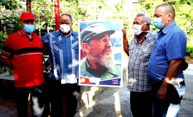 Combatientes reciben un cuadro de Fidel Castro en Cuba.