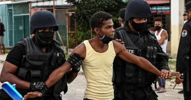 Arresto de un joven durante las protestas en Cuba.