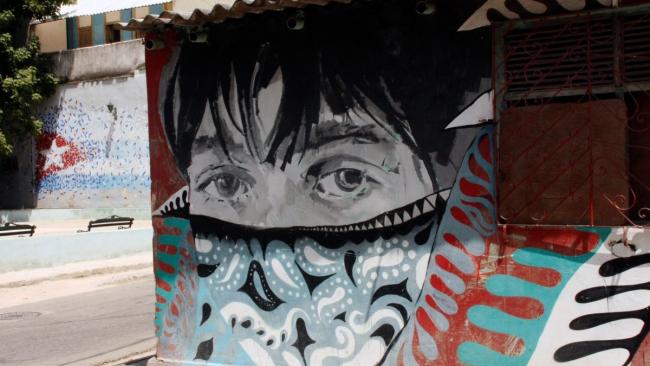 Grafiti en Cuba de una niña con nasobuco.