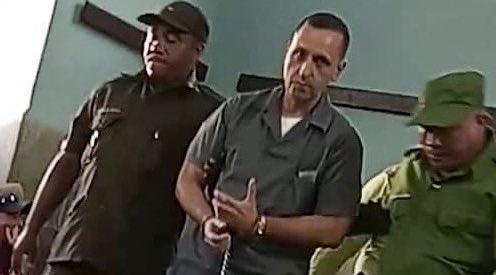 El preso político cubano Ernesto Borges, conducido por dos militares.