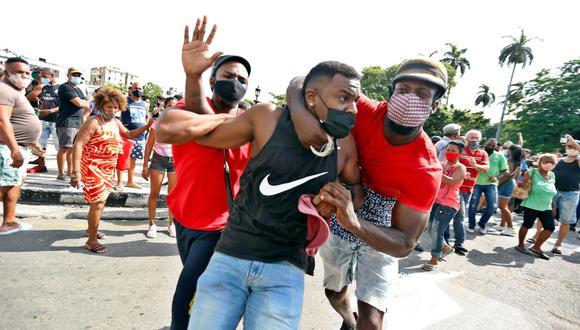 Dos personas detienen a un hombre durante una manifestación en La Habana, Cuba. 