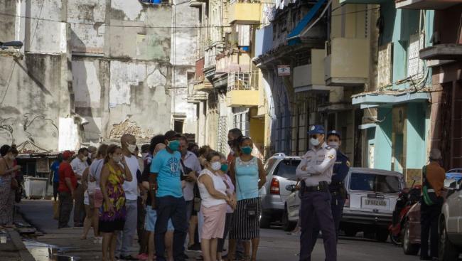 Personas con nasobuco en una cola en La Habana.