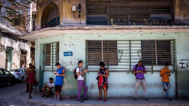 Cubanos conectados a internet en la calle.