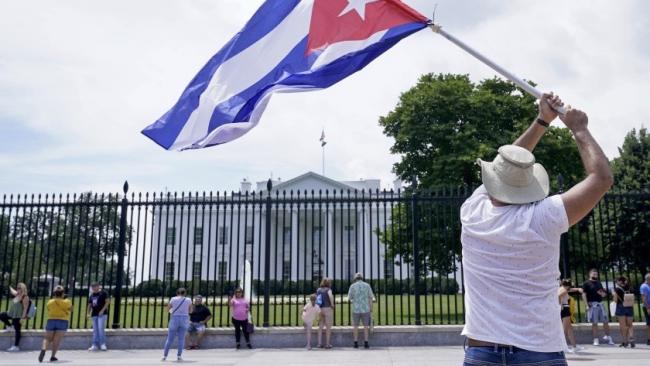 Un hombre con una bandera cubana ante la Casa Blanca.