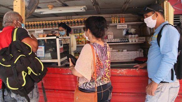 Cubanos compran en una tienda con la libreta de abastecimiento.