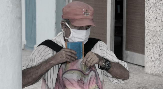 Un anciano guarda su libreta de racionamiento.