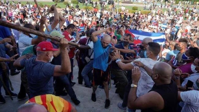 Partidarios del régimen de civil apalean a un manifestante el 11J en La Habana.