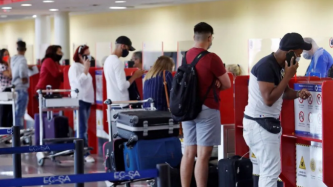 Viajeros chequeando sus documentos de viaje y pasajes en un aeropuerto en Cuba.