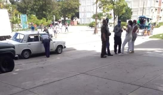 Policías pidiendo explicaciones a personas vestidas de blanco en el distrito José Martí de Santiago de Cuba.