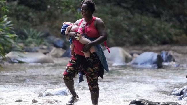 Una madre migrante y su hijo en la selva del Darién.