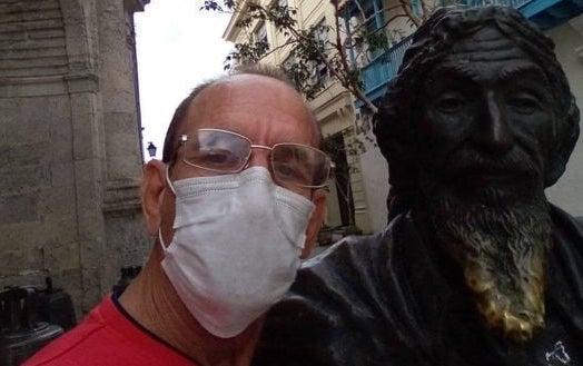 El profesor cubano Pedro Albert Sánchez junto a la estatua del Caballero de París en La Habana Vieja.