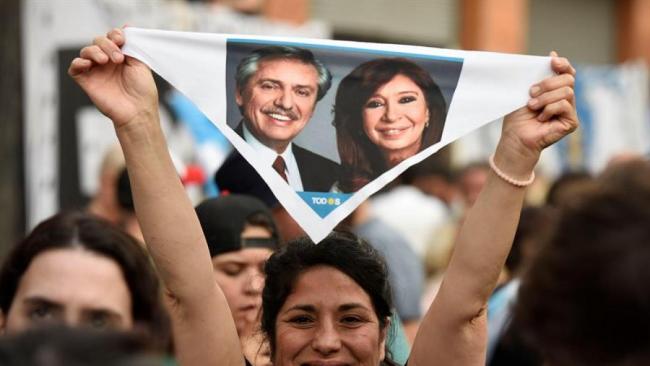Una argentina con un cartel de Alberto y Cristina Fernández.