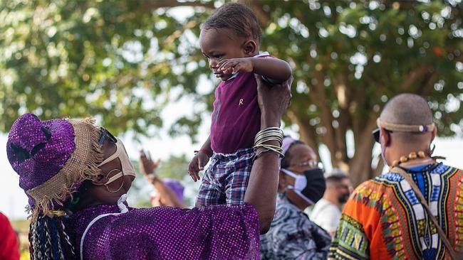 Una mujer carga a un niño en El Rincón.