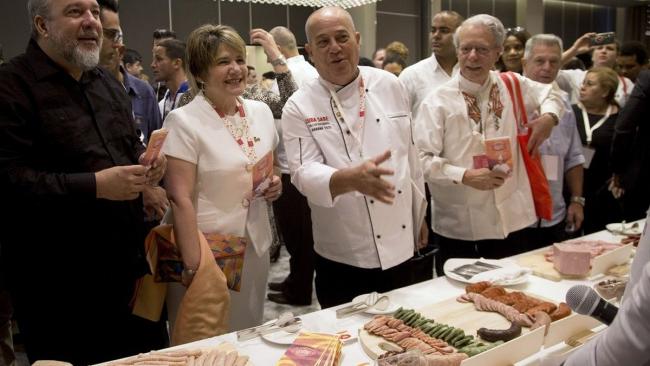 Frei Betto (der.) junto al primer ministro Manuel Marrero y la primera dama Lis Cuesta en un evento gastronómico en La Habana.