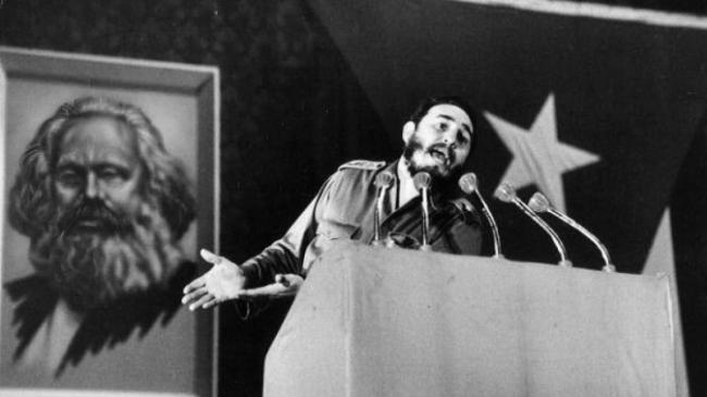 Fidel Castro en una de sus alocuciones. Detrás, retrato de Marx.