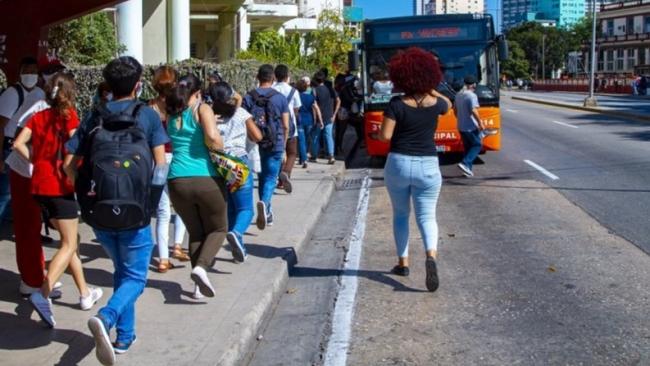 Cubanos esperan por la llegada de una guagua.