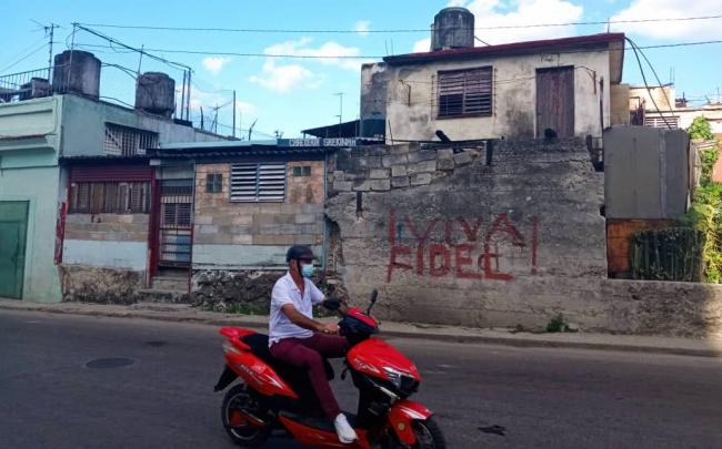 Un cubano pasa ante una pintada procastrista en una calle de La Habana.