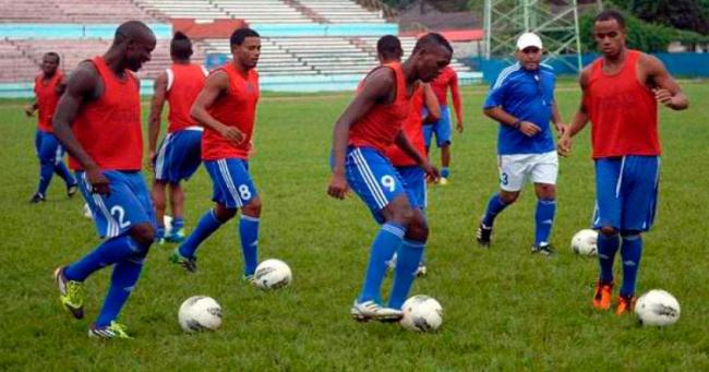 Cubanos entrenan antes de un partido de fútbol.