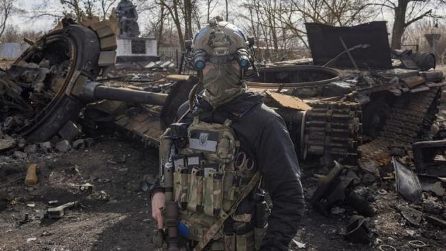 Un militar ucraniano pasa junto a los restos de un tanque ruso en Lukyanivka en las afueras de Kiev, Ucrania.