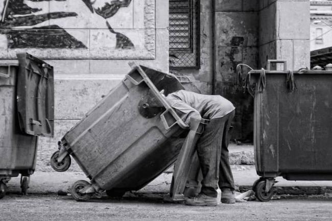 Un hombre buscando en un tanque de basura, La Habana Vieja, 2016. 
