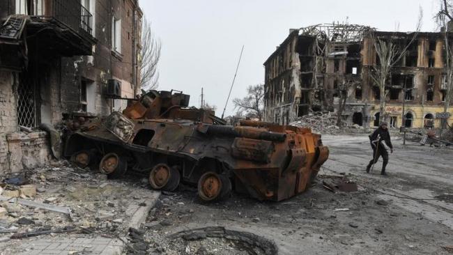 Un vehículo blindado quemado cerca de edificios destruidos en la ciudad portuaria sureña de Mariupol, Ucrania, 1 de abril de 2022. 