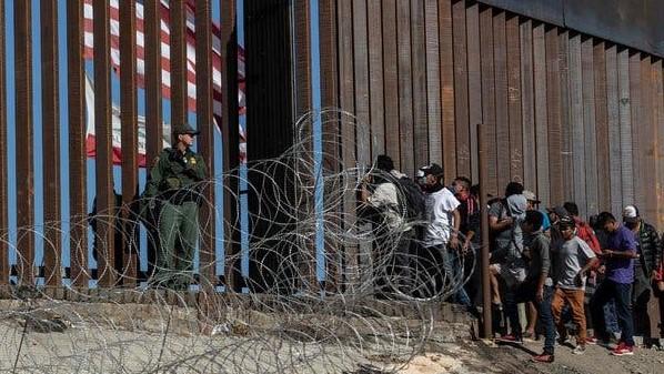 Migrantes en el muro fronterizo entre México y EEUU.