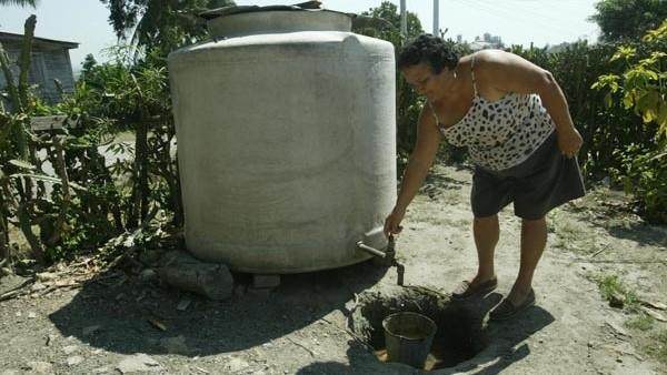 Una mujer en busca de agua almacenada.