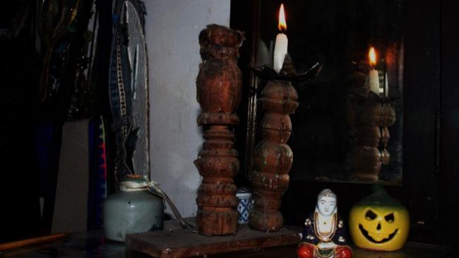 Una vela alumbra unas reliquias de santos en La Habana.