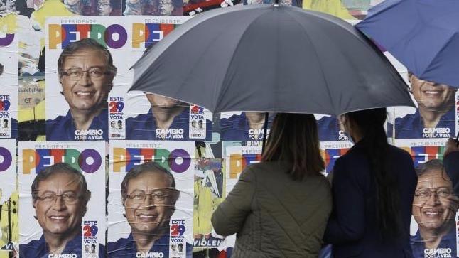 Dos transeúntes ante propaganda electoral en Bogotá.