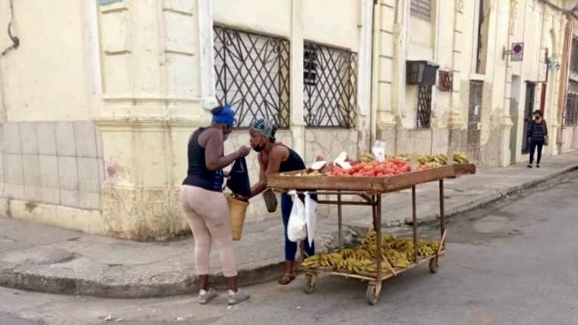 Una 'cuentapropista' y una clienta en una calle de La Habana.