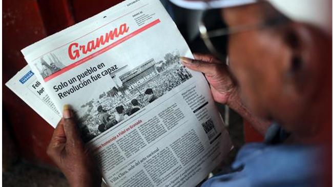 Un cubano lee el diario oficial del Partido Comunista.
