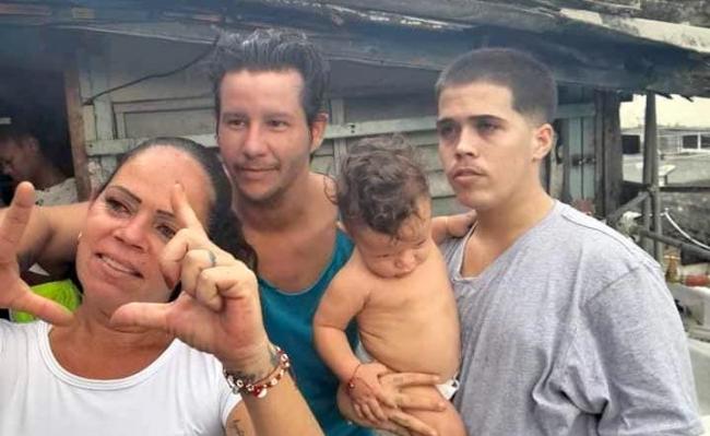 Jonathan Torres Farrat (der), con su bebé en brazos, su madre, Bárbara Farrat, y el activista Arian Cruz.