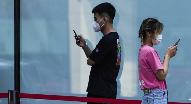 Dos internautas chinos revisan sus móviles.