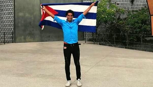 El artista cubano Luis Manuel Otero Alcántara con la bandera cubana.