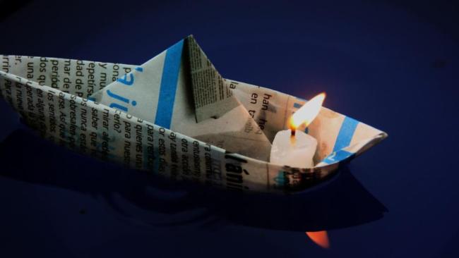 Una vela en un barco de papel.
