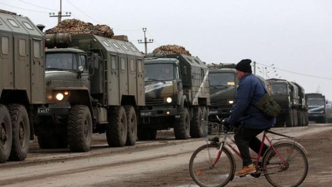 Un civil ucraniano en bicicleta ante una caravana militar rusa en Crimea.