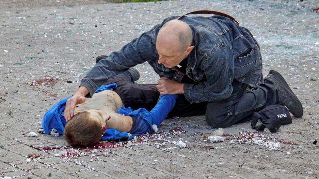 Un padre ante su hijo adolescente muerto en un ataque ruso en Ucrania.