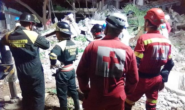 Fuerzas de rescate laboran para encontrar a la persona que está debajo de los escombros.