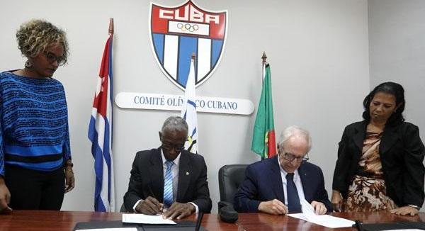 Los presidentes de los comités olímpicos de Cuba y Portugal durante la firma del acuerdo.
