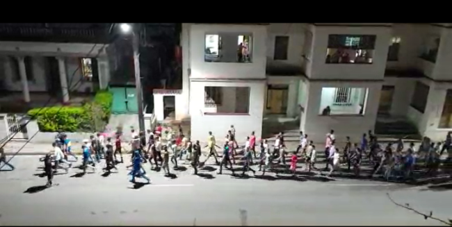 Cadetes cubanos desfilan con palos por una calle en el municipio Playa en La Habana.