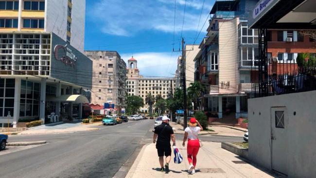Dos personas caminan por una calle del Vedado, en La Habana.