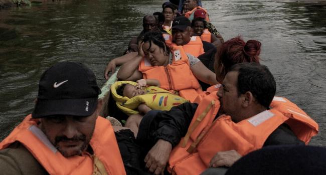 Migrantes de Cuba, Haití y Venezuela toman una canoa después de cruzar la selva del Darién para llegar a Panamá.