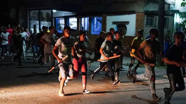 Paramilitares armados de estacas reprimiendo a manifestantes pacíficos a inicios de octubre en La Habana.