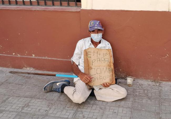 Un hombre mayor pide dinero en una calle de La Habana.
