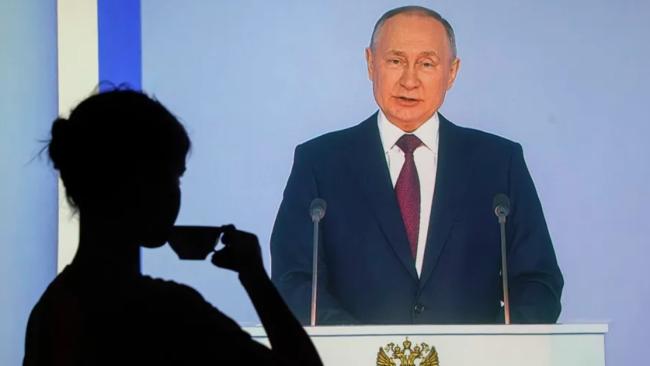 Una mujer sigue por televisión la intervención del presidente ruso, Vladimir Putin, ante la Asamblea Federal en Moscú.