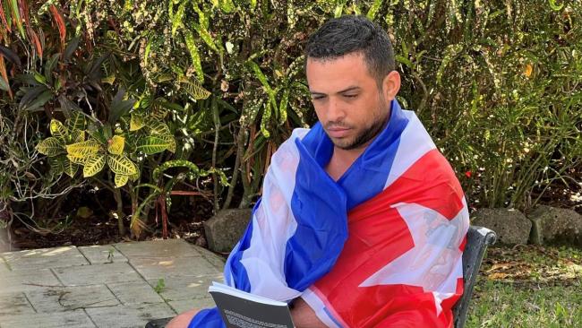 El activista Héctor Valdés Cocho envuelto en la bandera cubana.