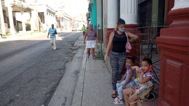 Una madre con sus hijas en una calle de Cuba.