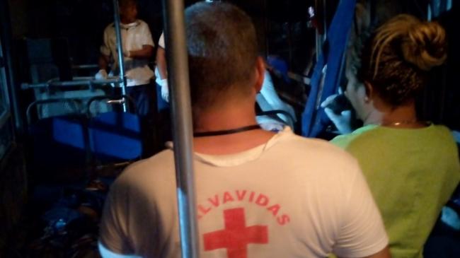 Personal de la Cruz Roja y paramédicos en el interior de una guagua convertida en ambulancia.